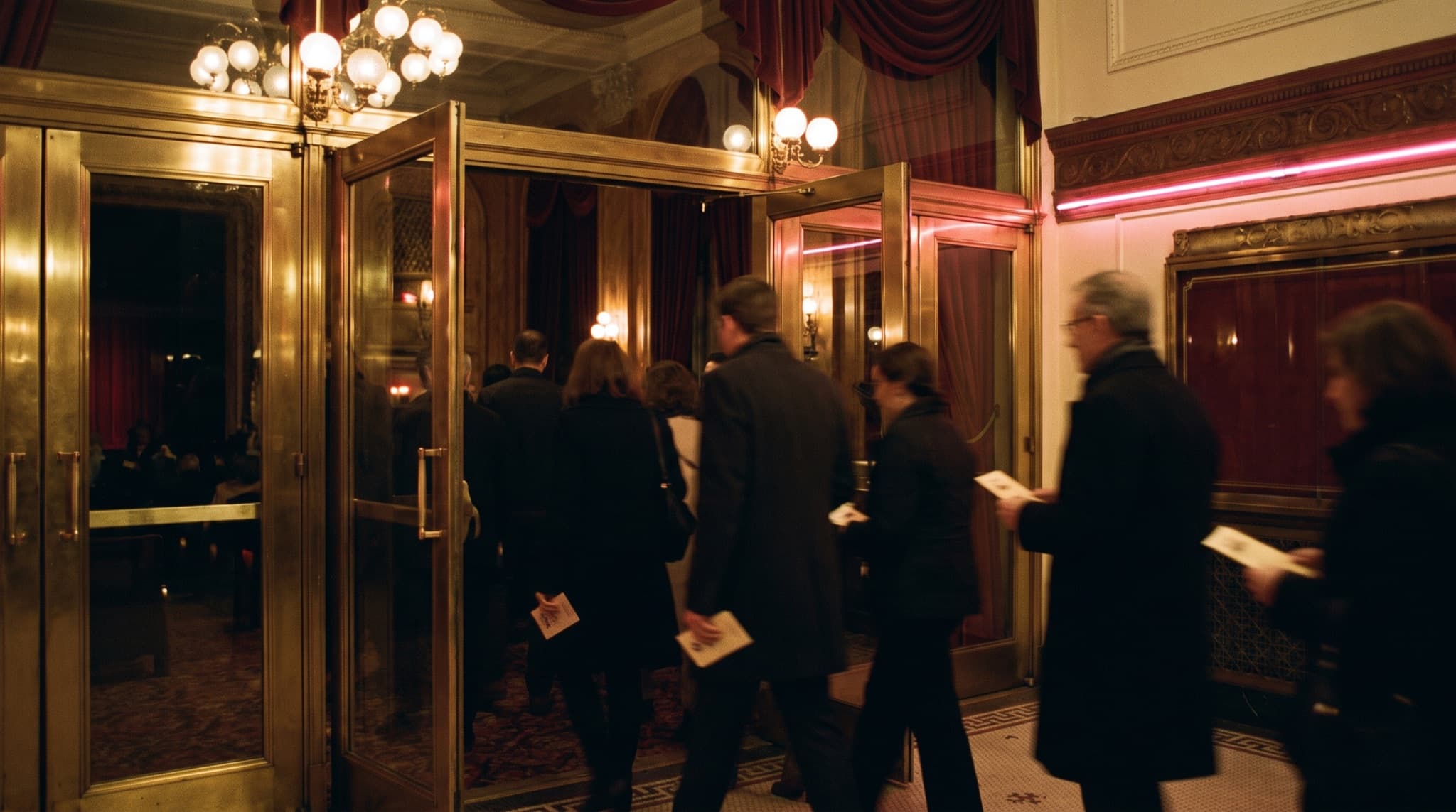 A phone ticket being scanned at the venue door with a crowd behind