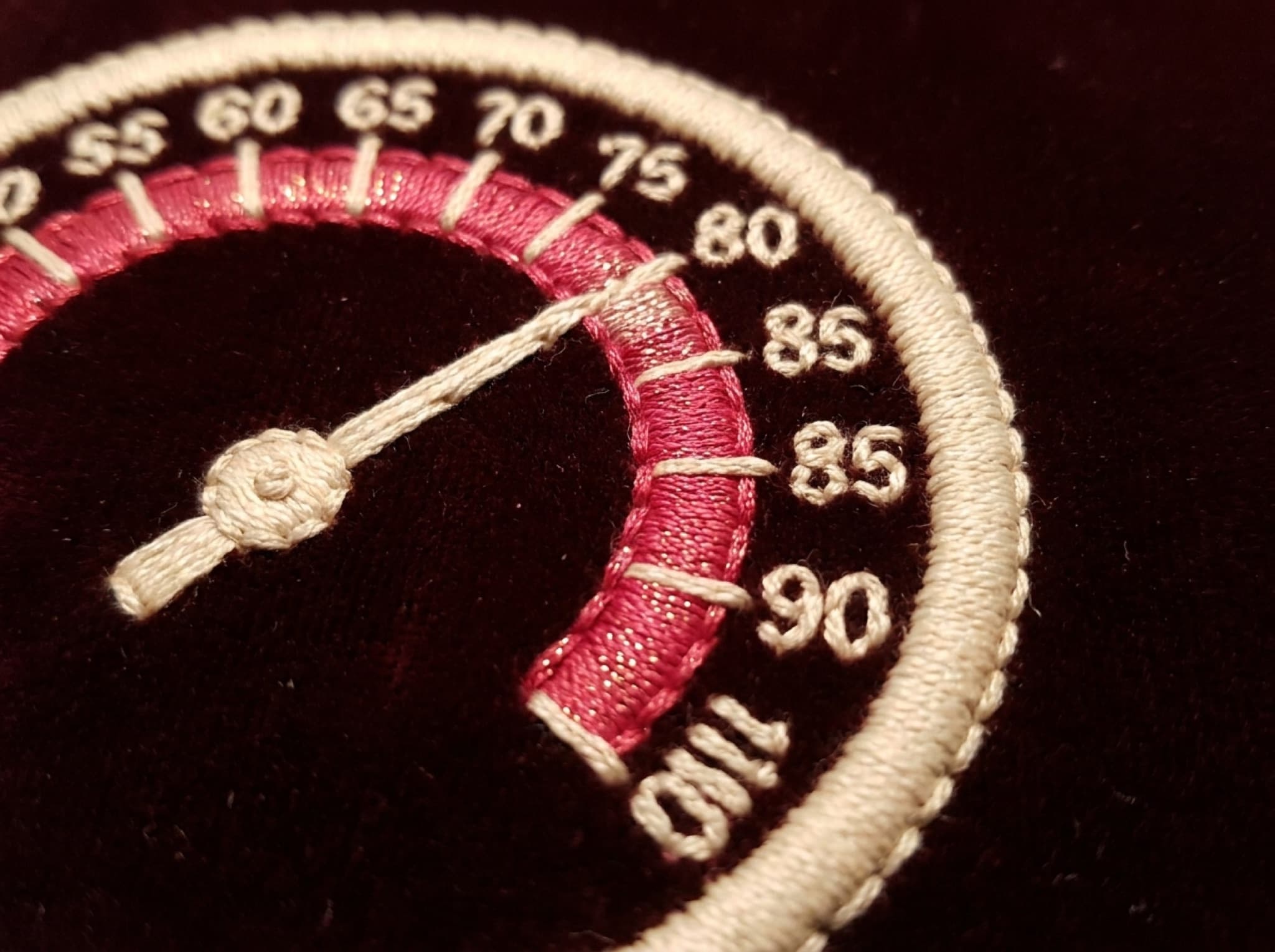 A stitched thermometer goal meter on velvet